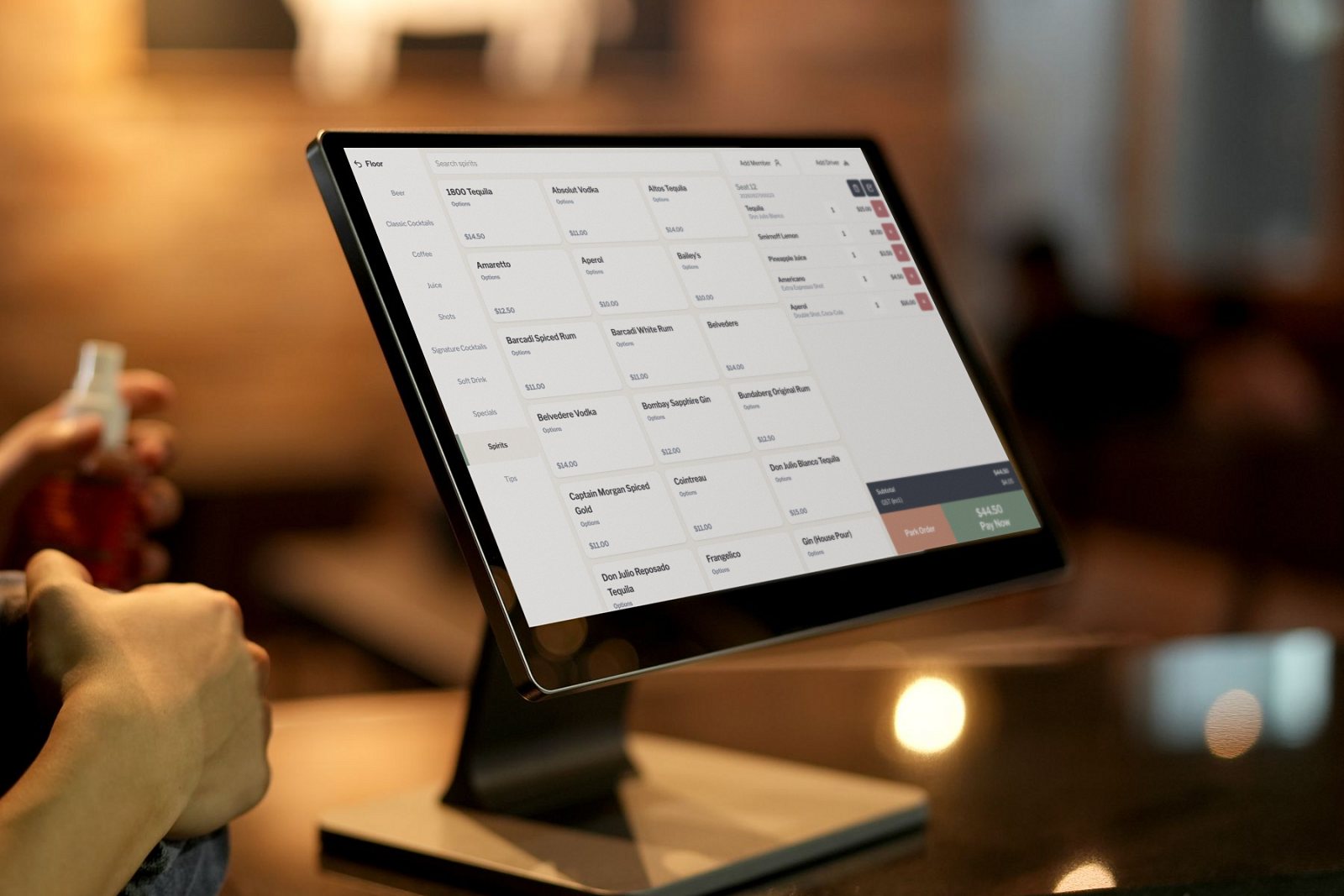 Live Hospitality POS order screen on a countertop terminal in a bar: spirits menu, an open ticket and a $44.50 Pay Now button